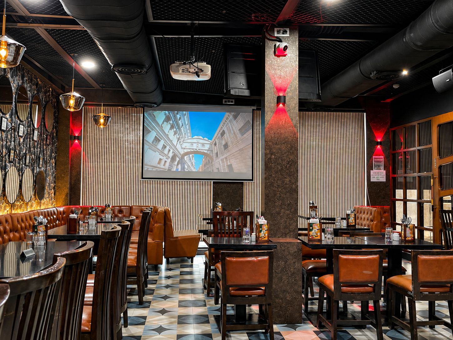 Standing-height social tables with metal stools in the lounge area of Big Bull Cafe Chakala